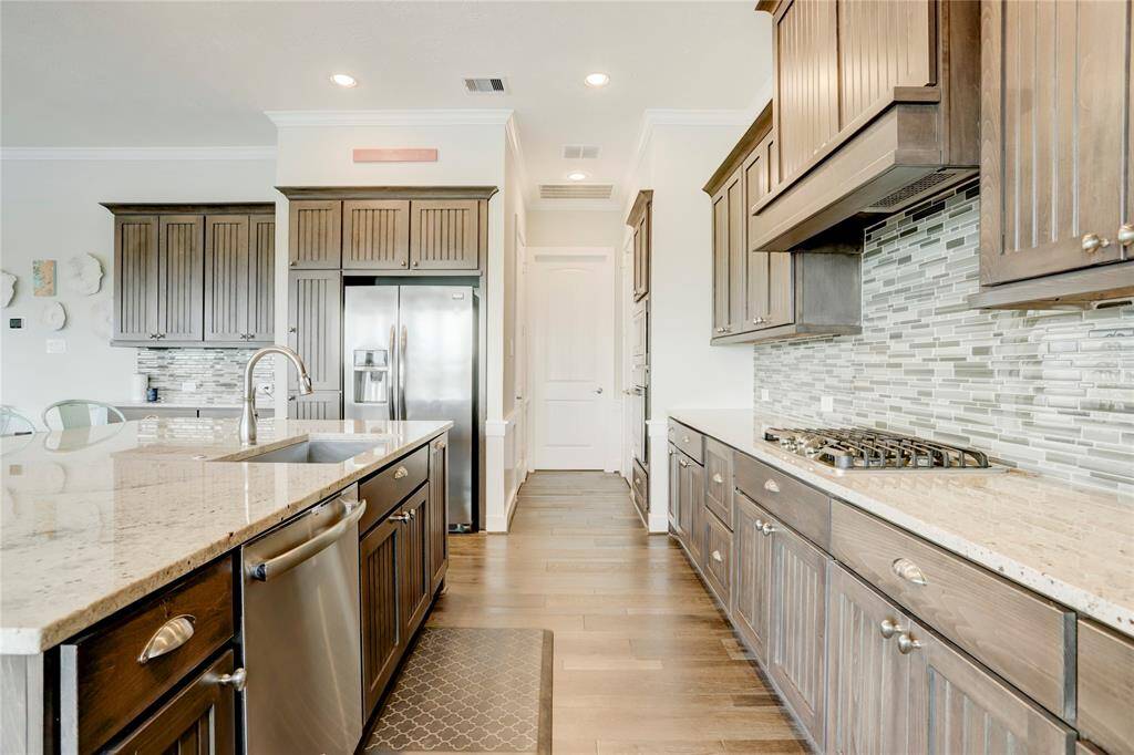 ATTENTION TO DETAIL ISEVIDENT IN THIS STYLISHKITCHEN. THE HIGH-END GASCOOKTOP IS SET AGAINST THESTYLISH BACKSPLASH, WITH THEHOOD CONCEALED WITHIN THECABINETRY FOR A SLEEKAPPEARANCE.