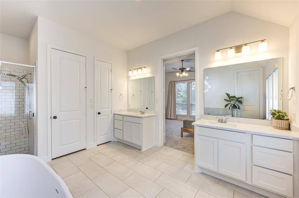 Primary bath includes dual vanities, subway tile, glass enclosed shower, xl freestanding soaking tub, and extended walk-in closet upgrade.