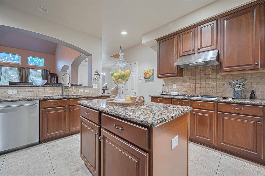 There is a gas range with tumble stone backsplash and upgraded fan.