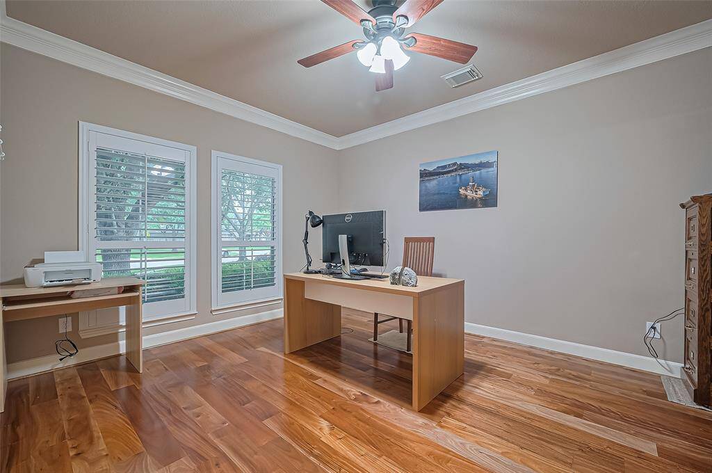 The home office/study overlooks the front of the home. It has plantation shutters and the Brazilian wood floors.