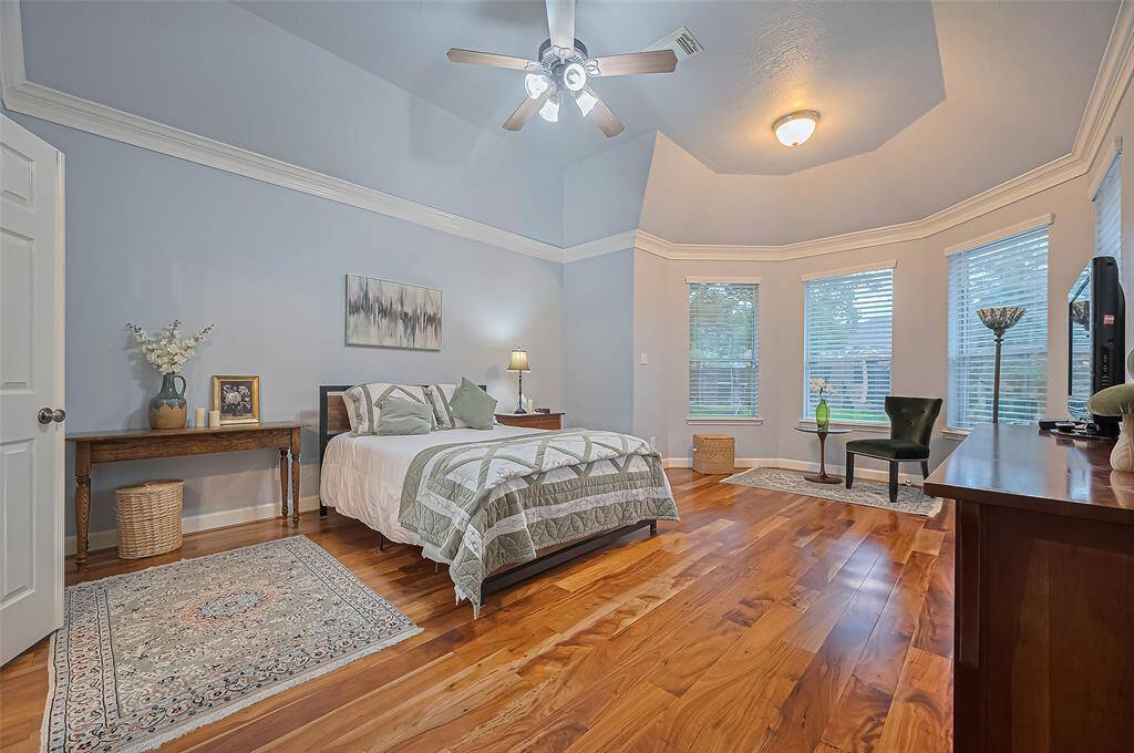 The soothing primary bedroom has bay windows with a view of the garden and pool. It has a lovely sitting area.