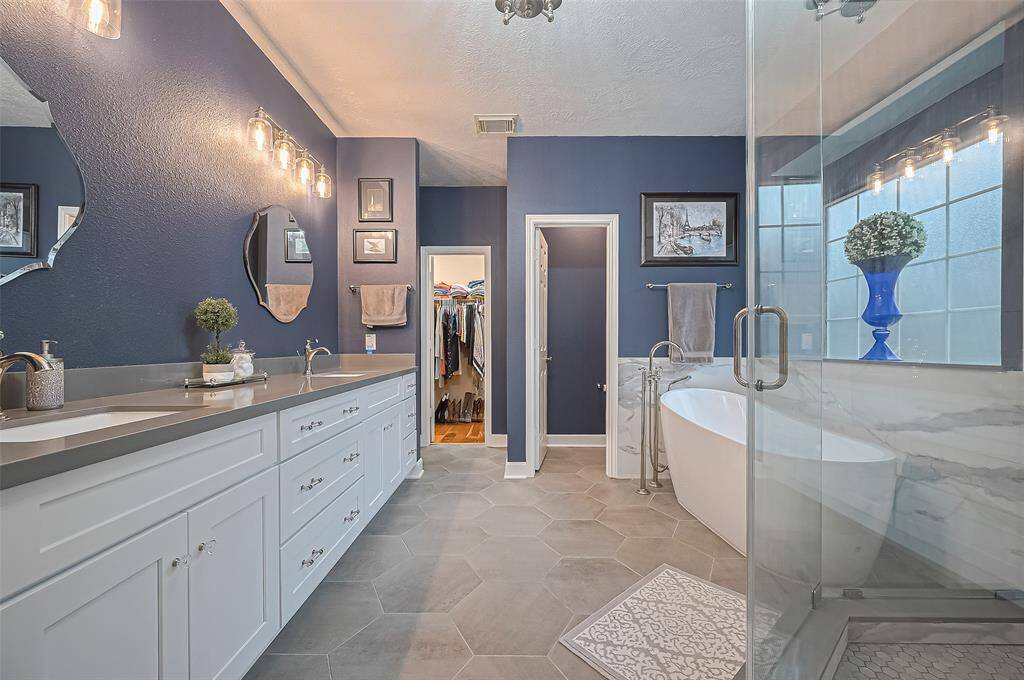 The primary bathroom is upgraded. There are dual sinks with a soaking tub and shower. Large walk in closet at the end. And another walk in linen closet on the side.