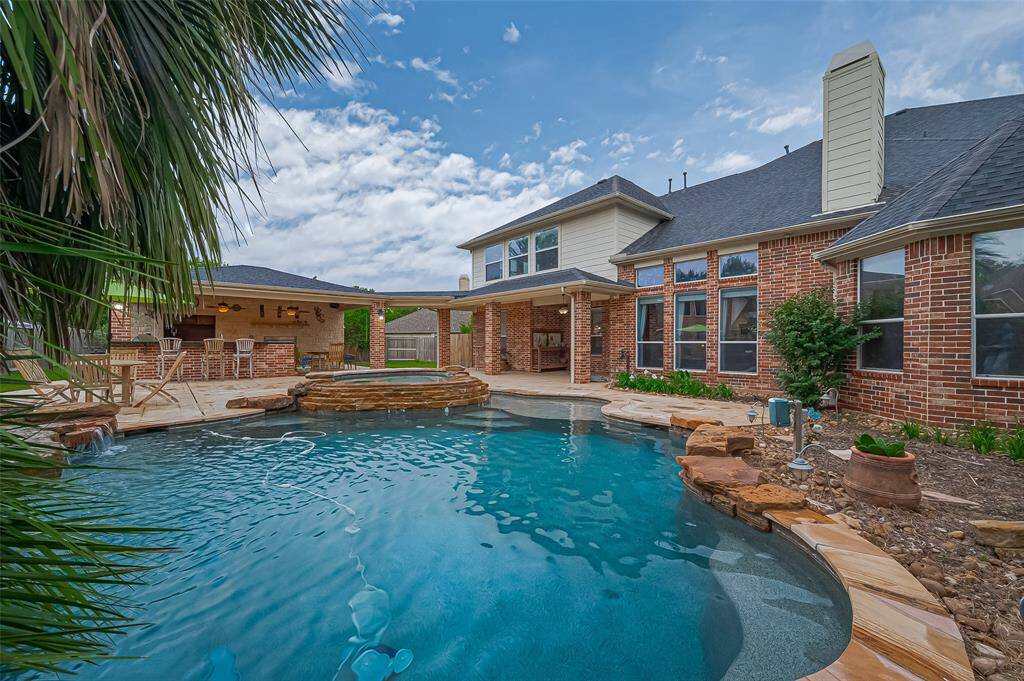 A view of the home, outside kitchen and pool.