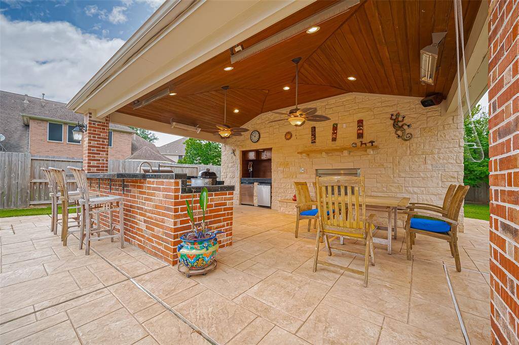 It boasts a chef full kitchen, fireplace, and heaters. You can see the beer taps and fridge to the back left. There is shower for the pool on the right side. In the back there is a half bath and storage.