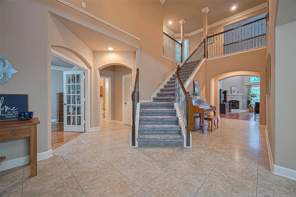 There is a sweeping iron staircase. On the left, there is a full guest bathroom and the closed door leads to utility room which has a full size washer and dryer. It also has room for a second fridge.