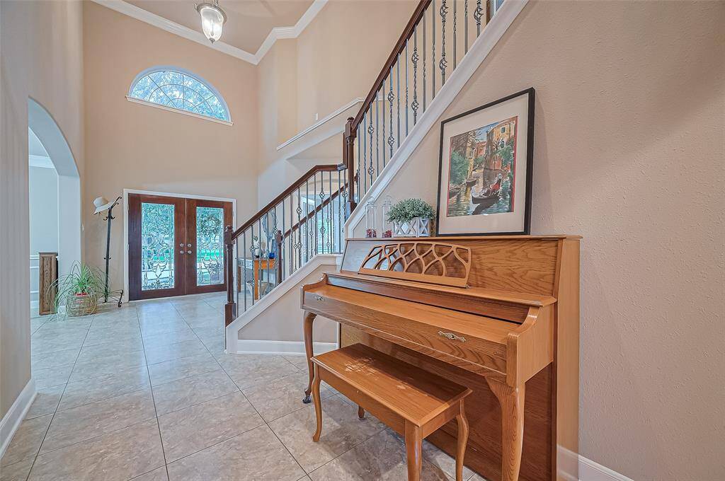 The wide hallway extends into the family room. At the forefront there is a large under the stairs coat closet.