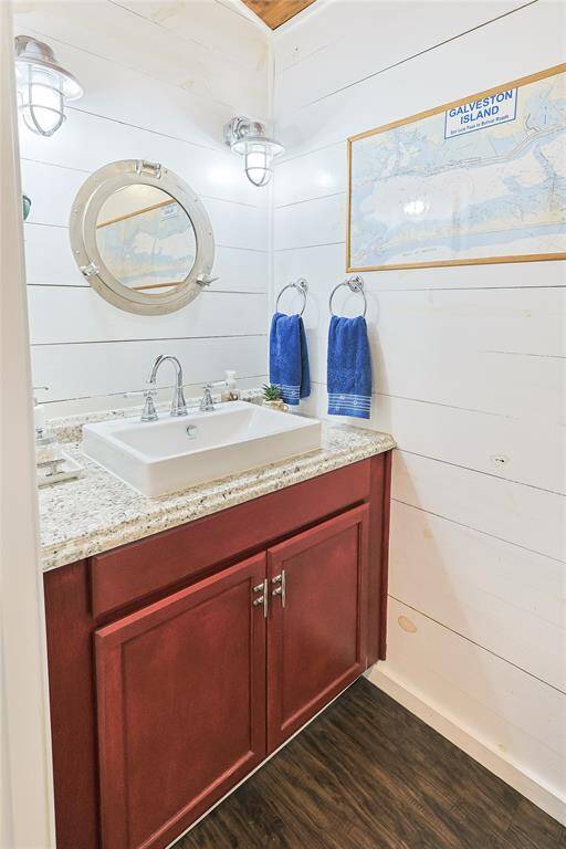 Charming shiplap bathroom with nautical touches add to the water-themed charm of this home by the bay.
