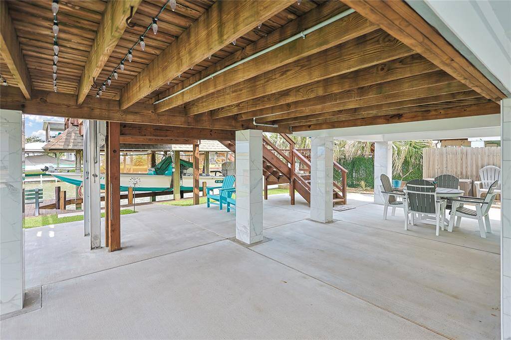 The ground floor covered patio is accented with custom-tiled beams, adding a stylish touch to this inviting outdoor space- ideal for waterfront lounging or entertaining.