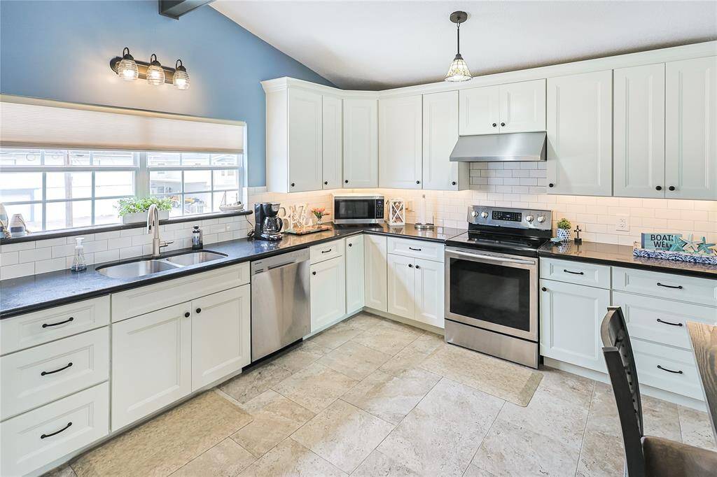 The light-filled kitchen features timeless subway tile backsplash, custom cabinetry, and a clean, coastal design perfect for cooking and entertaining.