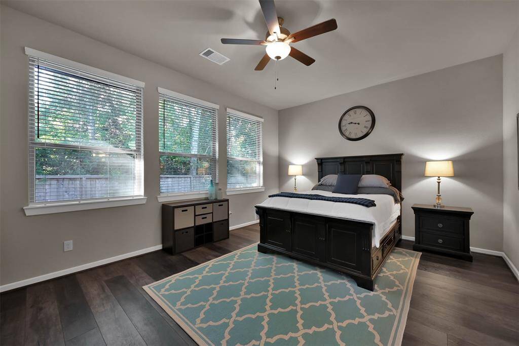 This primary suite features a spacious layout with large windows allowing natural light to fill the room.