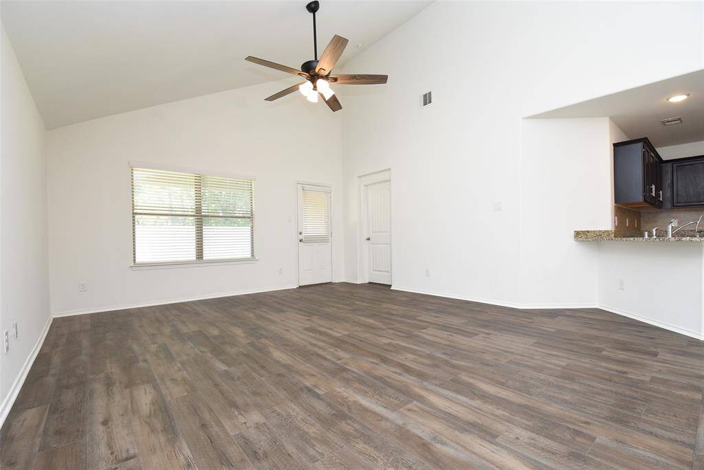 Beautiful vinyl plank flooring anchors the living room. Door to back covered patio.