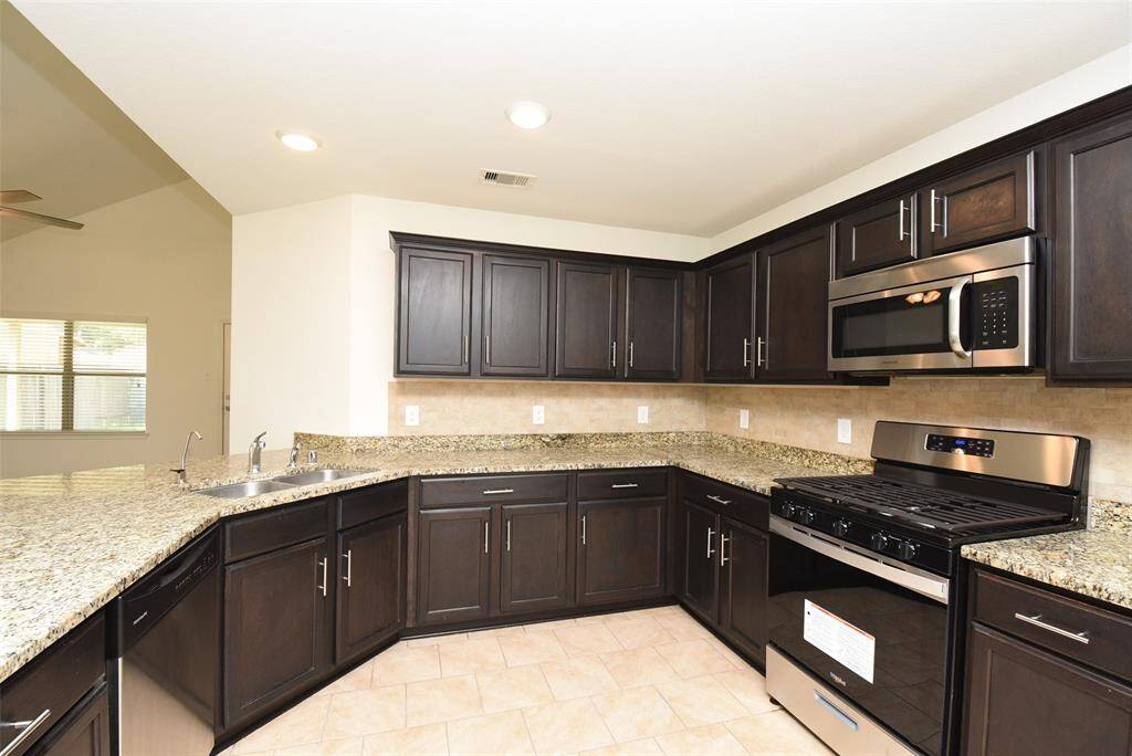 Stylish dark espresso cabinets accentuate the kitchen.