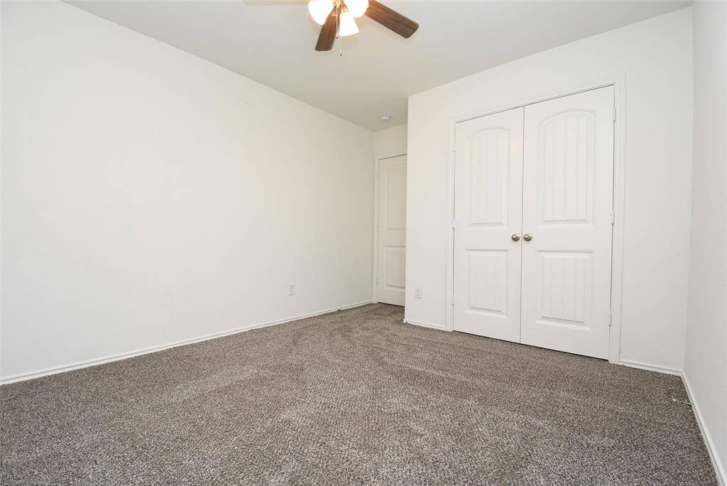 Bedroom 2 features a ceiling fan, carpet & neutral paint.