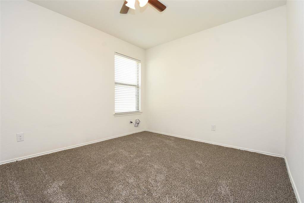 Bedroom 3 features a ceiling fan, carpet & neutral paint.