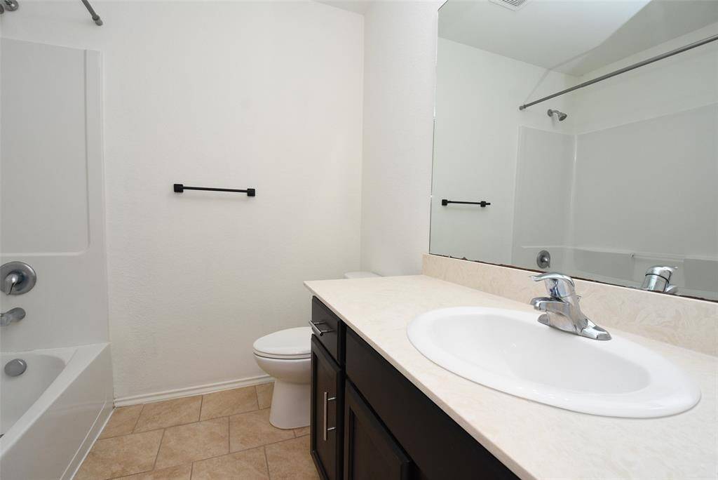 Hall bath has a large vanity area & tub/shower combo.