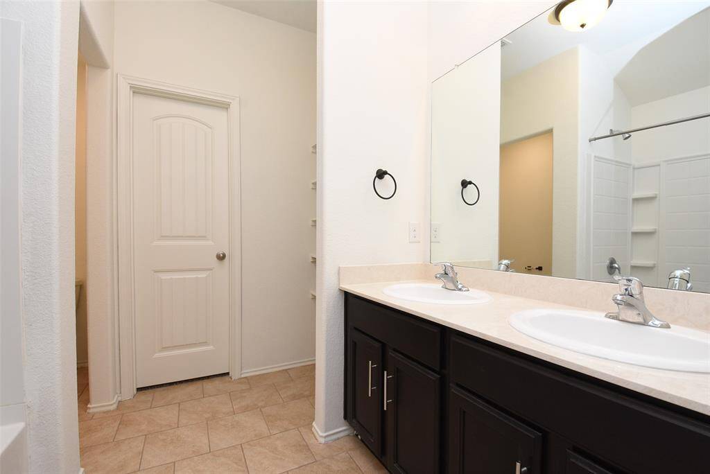 Ensuite primary bath w/ dual sinks & tub/shower combo.