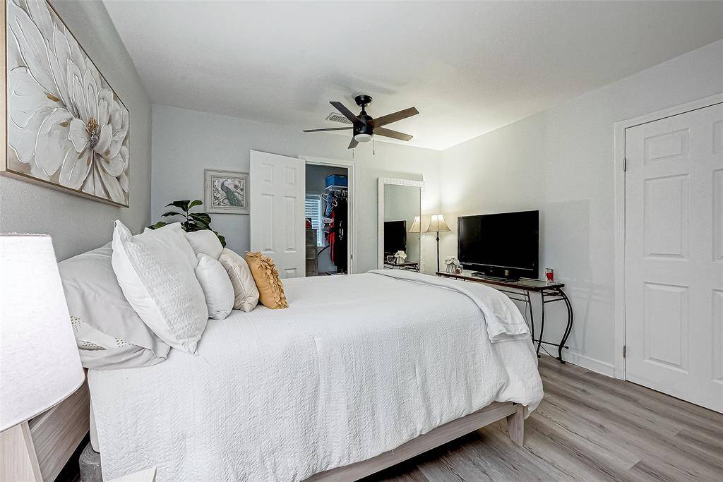 This bedroom features a cozy, modern design with light gray walls and wood flooring.