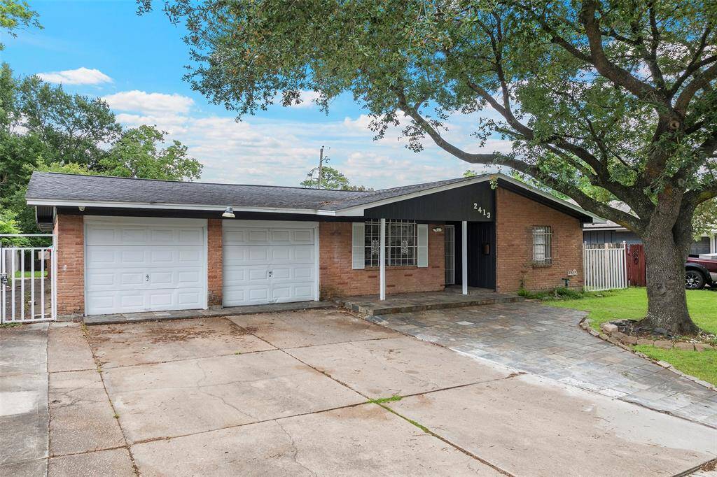 Charming single-story brick home with a double garage and a spacious driveway. Features a welcoming front porch, mature trees, and a well-maintained lawn, providing great curb appeal.
