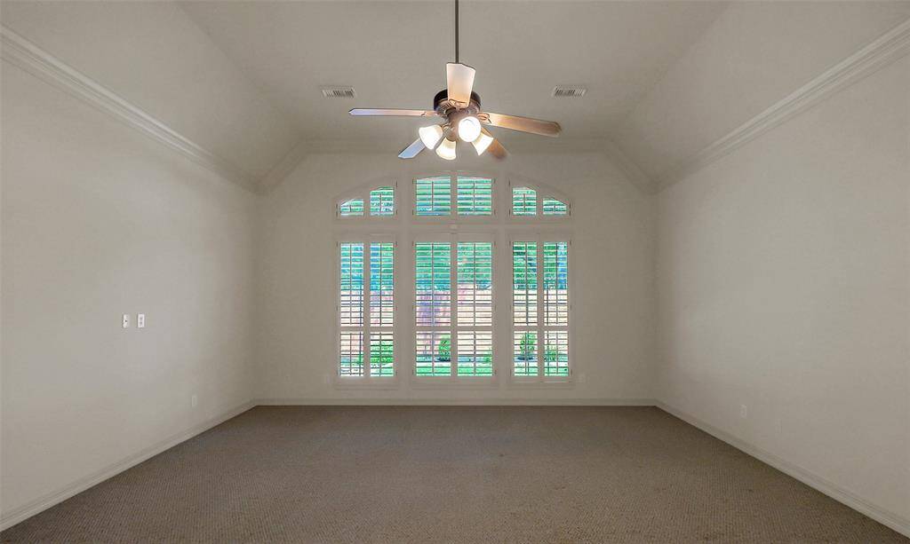 The graceful arched window has plantation shutters.
