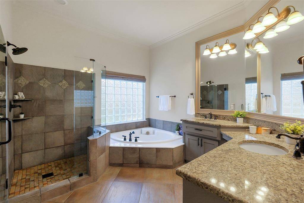 Spacious primary bathroom with walk in shower, corner bath and double vanities.