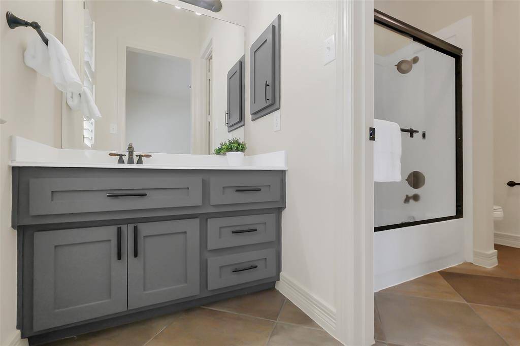 The Jack and Jill bathroom directly connects to one bedroom and has hall access to the other bedroom.