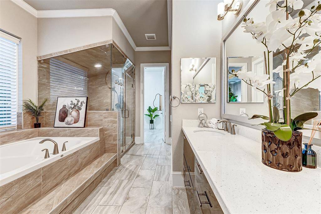 Primary bathroom suite with soaking tub, privacy window and dual sinks.