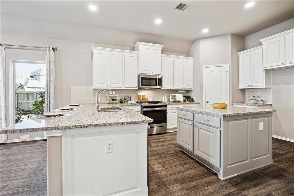 Breakfast bar with deep overhang makes a great workspace or eating area. Central island with storage and plenty of countertops will keep you organized and on top of your culinary game.