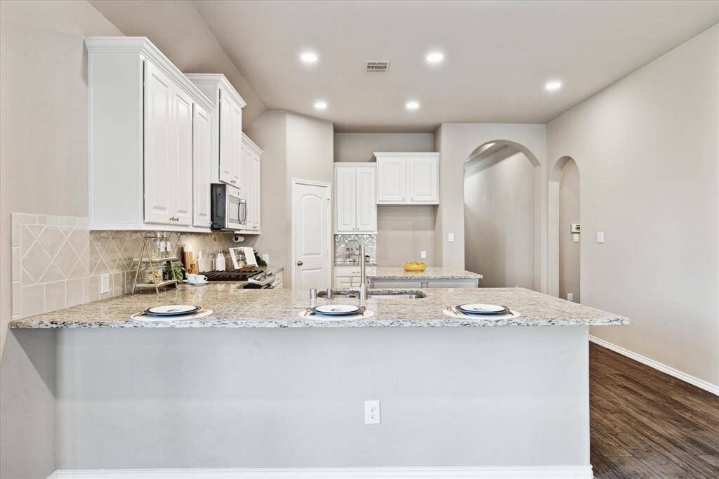 Kiss the cook! This kitchen makes that easy with the open design and functionality. Arched transitions and doorways through the home offer a Moorish nod and add architectural interest.