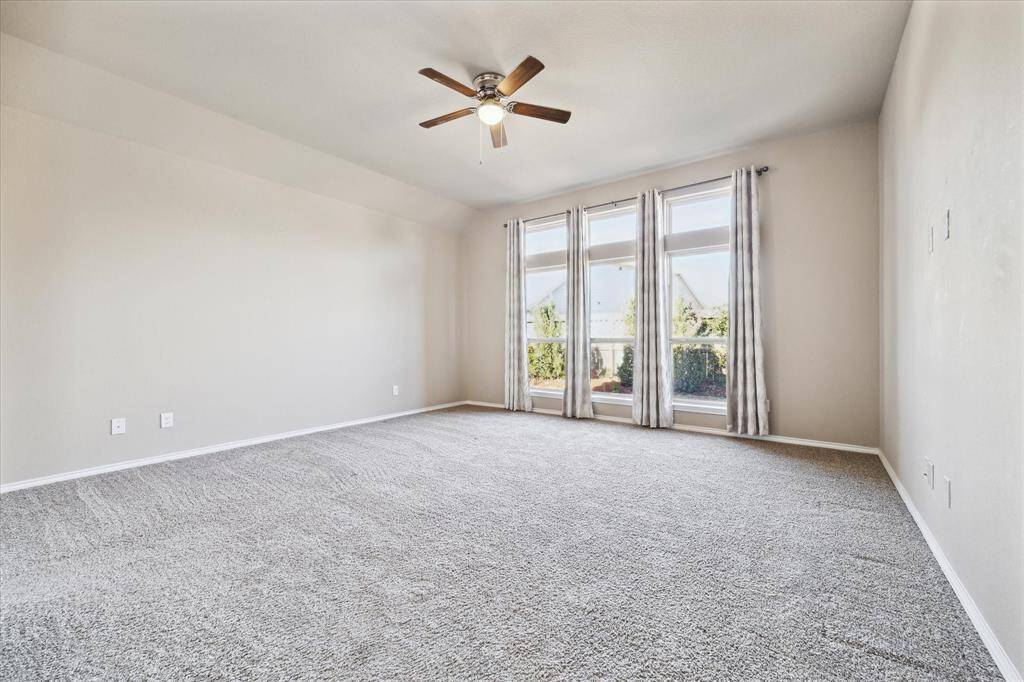 Enter the primary bedroom with a bank of windows, custom drapes and room to stretch out.
