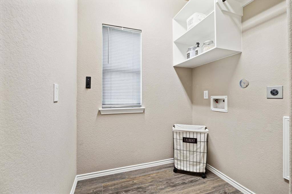 Windowed laundry room with shelving is just off the main hall. Spacious and functional with natural light that makes this chore enjoyable.