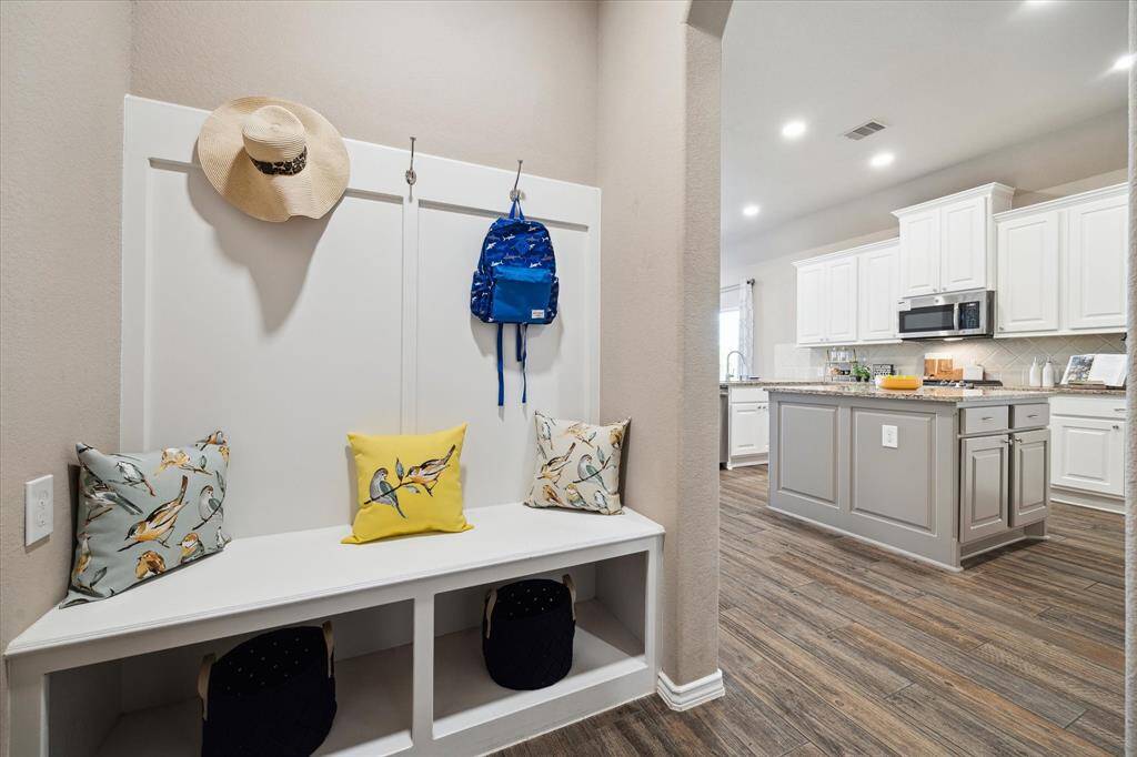 Mud room entry, storage and coat hangers are just inside the garage for a functional space and bench seating.