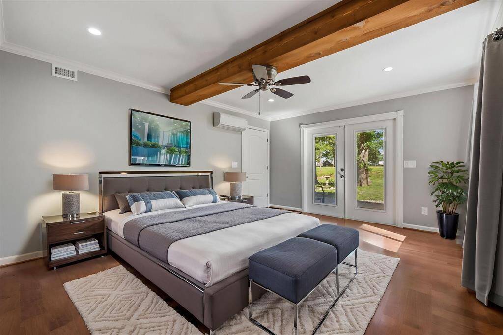 Virtually staged primary bedroom with French doors leading to a patio.