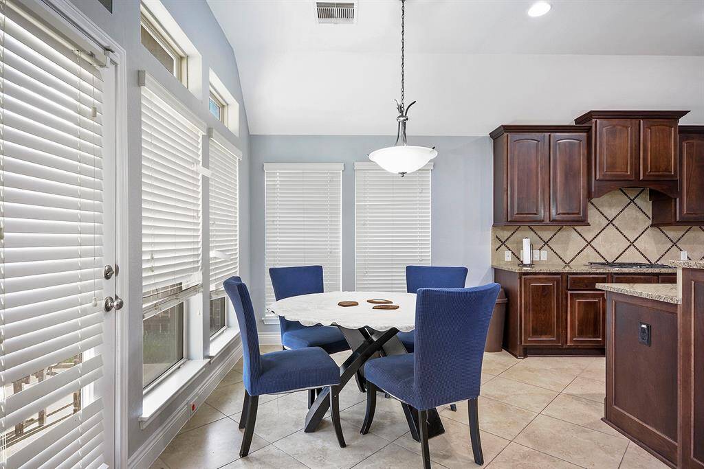 This is a DREAM KITCHEN! Open to the breakfast space and living room. Light fixture above breakfast table is another one of this homes many upgrades.