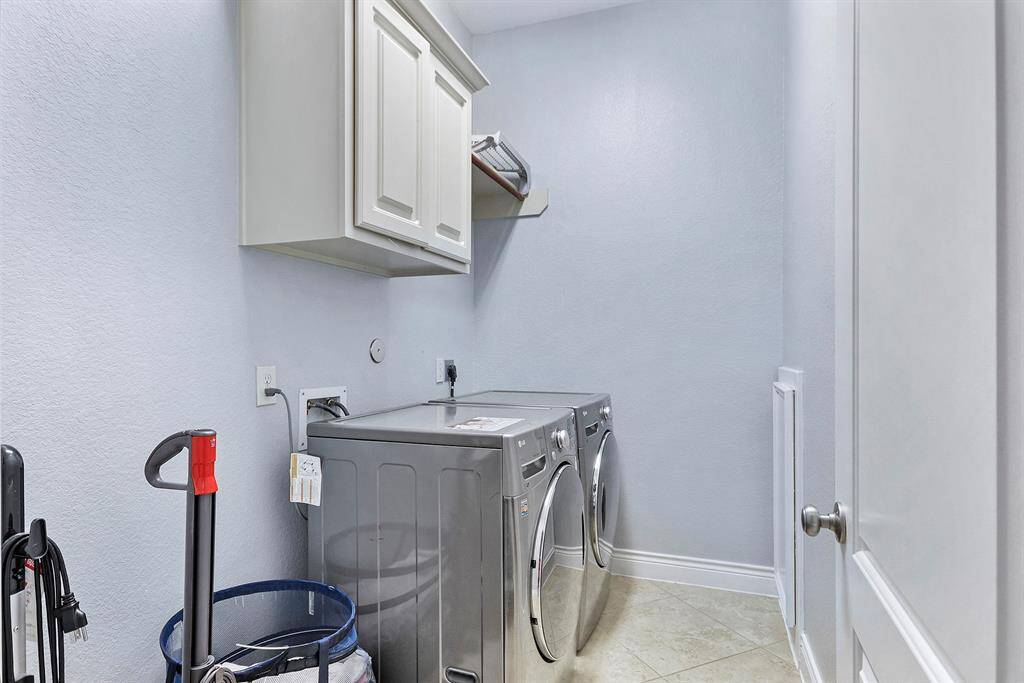 Utility room/Laundry room with cabinetry and a hanging rod. Possibly can fit an extra refrigerator or freezer.