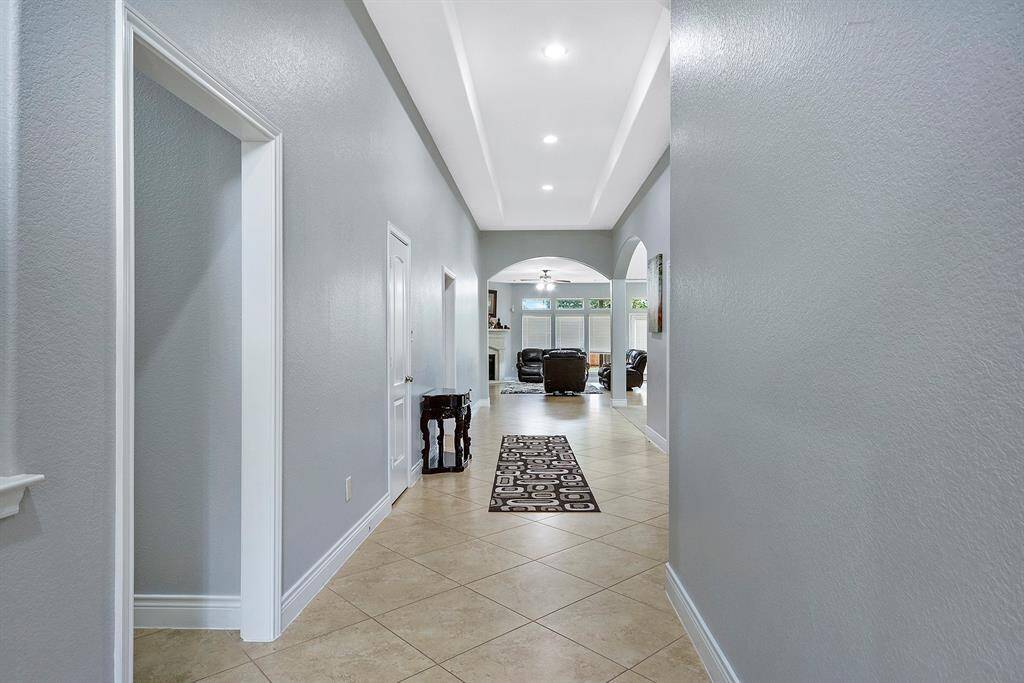 Inviting entryway Looking to the front door entrance. The left is easy access to the guest bedroom. Notice the high tray ceiling with tile flooring throughout the home.