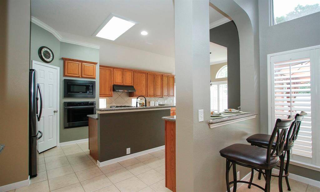 Step inside to a gourmet kitchen complete with quartz counters, tile backsplash, gas cooktop, extended island, breakfast bar, built-in desk and tons of cabinet space!