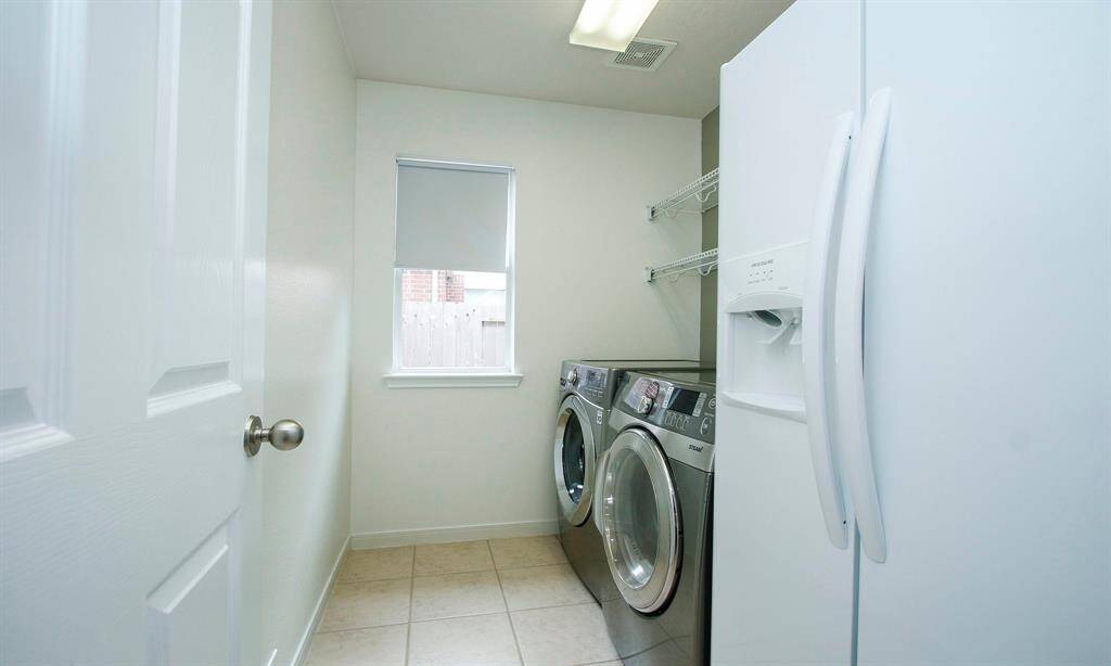 Utility room offers a washer, dryer, refrigerator and plenty of space for those everyday laundry needs!