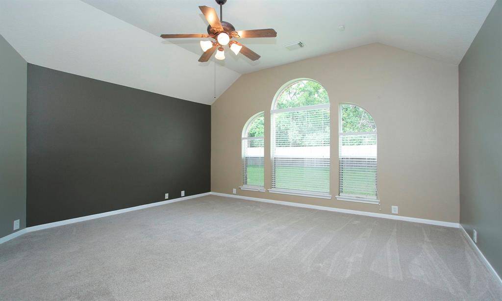A serene primary suite with recent carpet, vaulted ceiling and lovely backyard views.