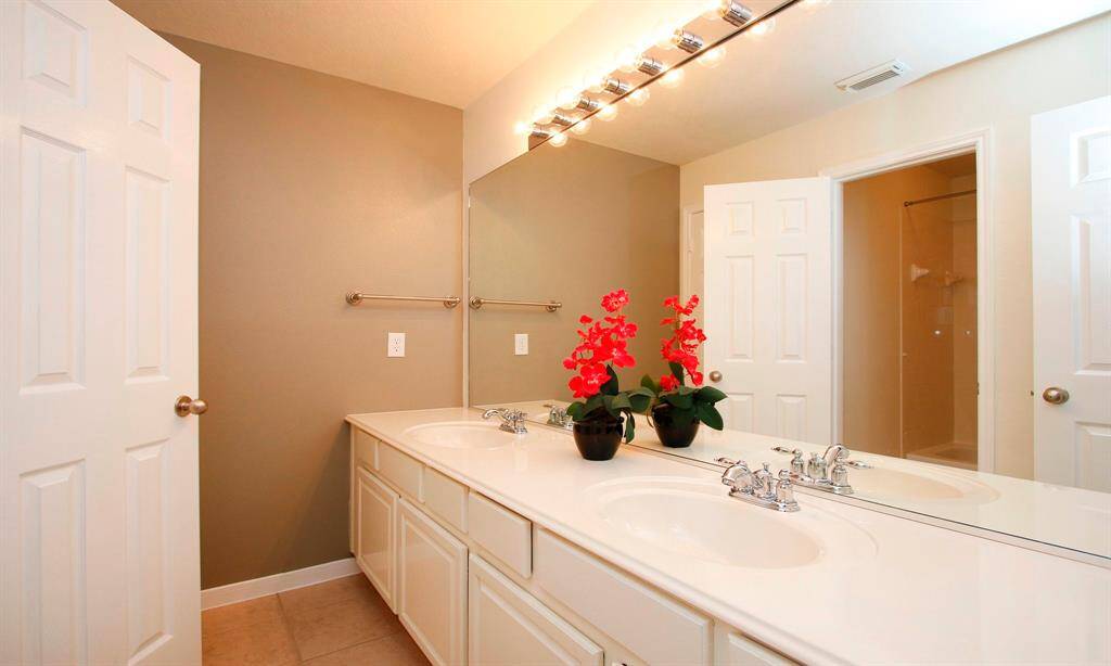 Secondary bath with dual sinks and tub/shower combo sits directly outside of secondary bedrooms.