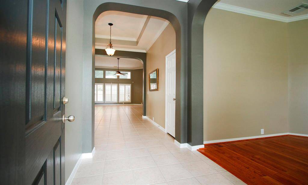 Upon entry you are greeted by a custom tray ceiling, crown molding and extended tile flowing through all main areas! The entry is adjoined by the home office on the right.