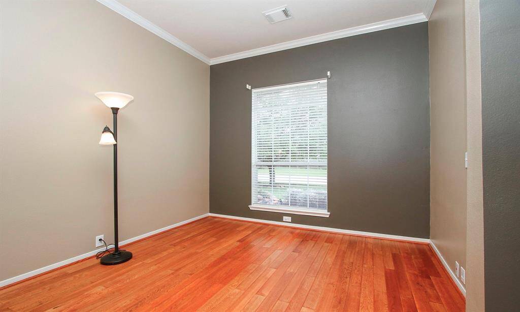 A handsome home office featuring hi-end wood-look tile floors, crown molding and lots of natural sunlight!