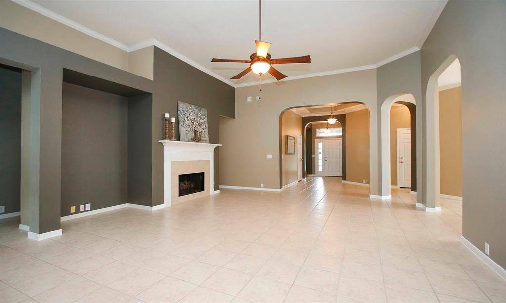 This family room is enhanced by beautiful archways and designer paint which can be seen throughout the home.