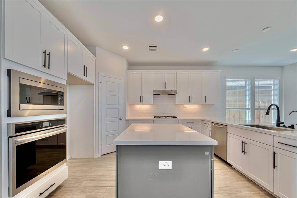 Enjoy a modern chef's kitchen with white cabinetry and a spacious double tone painted island. Enjoy an open layout perfect for entertaining and everyday living.