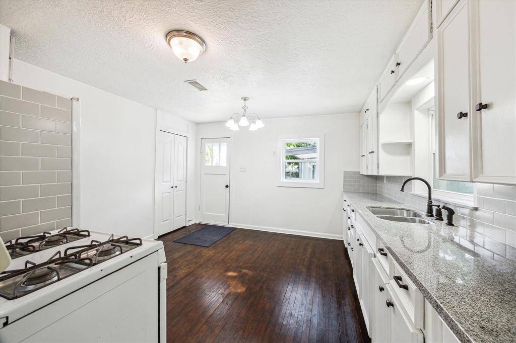 THE KITCHEN FEATURES GRANITE COUNTERS AND ORIGINAL WOOD FLOORS.