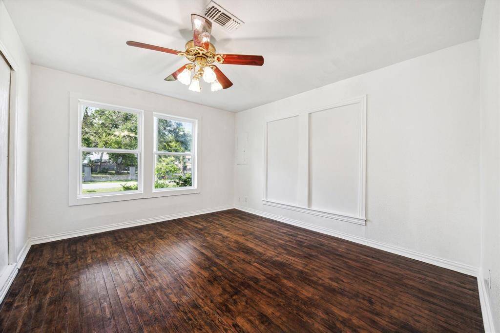 FRONT BEDROOM WITH REACH-IN CLOSET AND CEILING FAN.