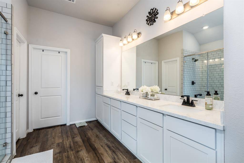 The primary bathroom features dual sinks, plenty of cabinets for storage. The light in this room is fabulous!
