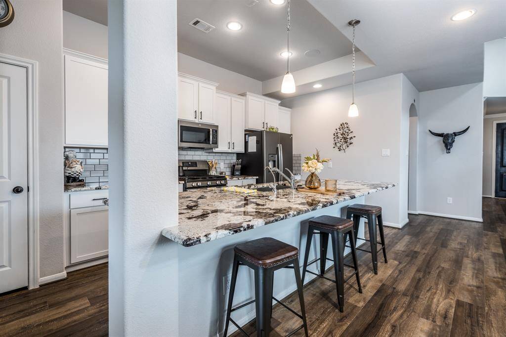 This kitchen offers plenty of storage, adorned with amazing granite countertops providing the perfect prep space for meals or rolling out cookie dough!