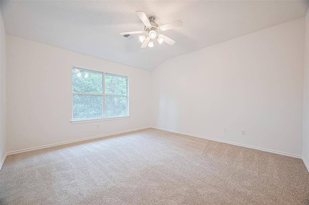 Spacious upstairs second bedroom with abundant natural light.