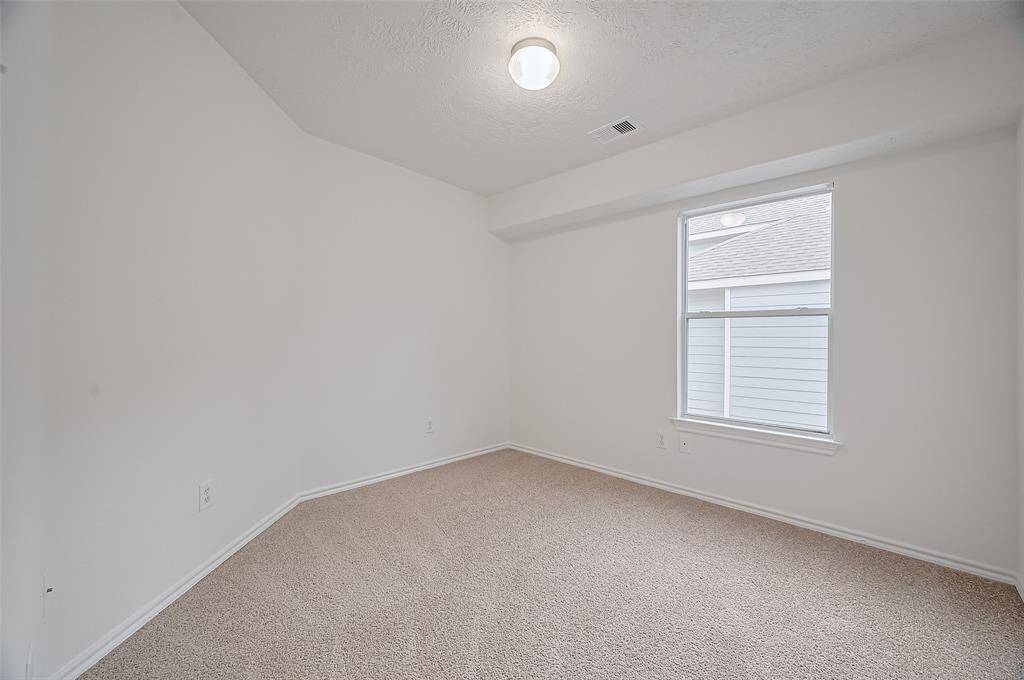Bright upstairs third bedroom with cozy carpeting and ample natural light.