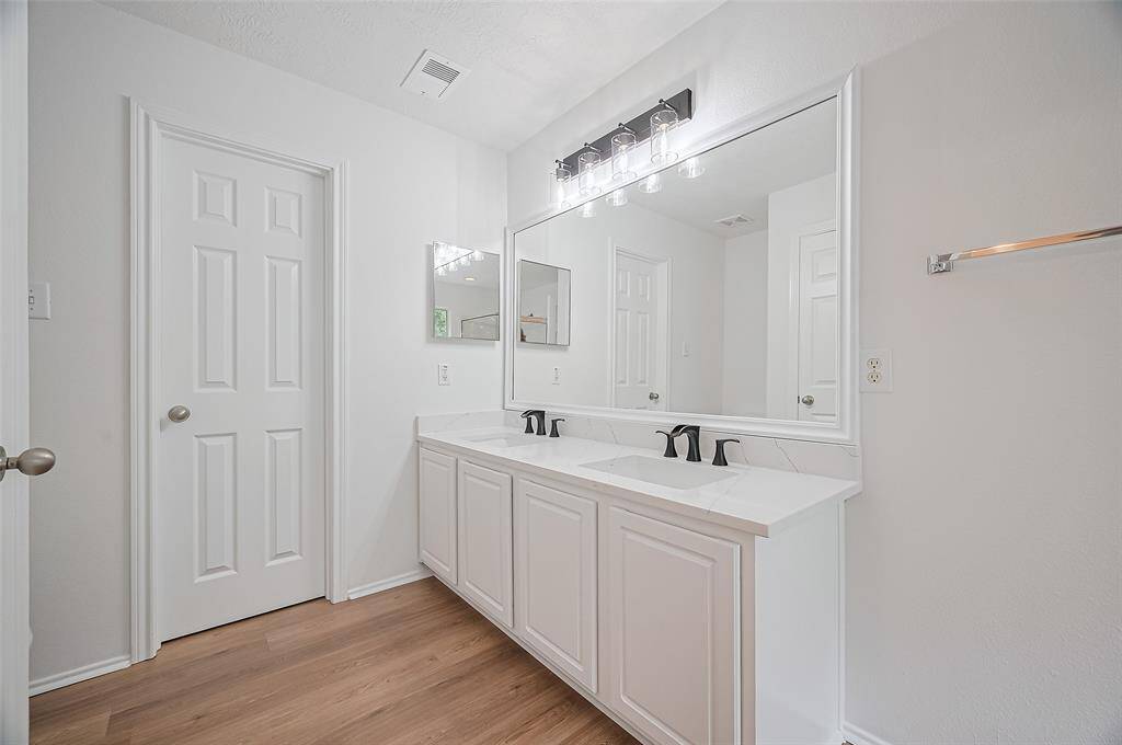 Spacious second bathroom featuring double sinks and a versatile tub/shower combo.